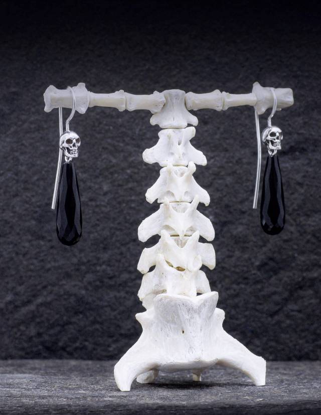 Detailed skull drop earrings with black gemstones made of sterling silver by Kipkalinka.