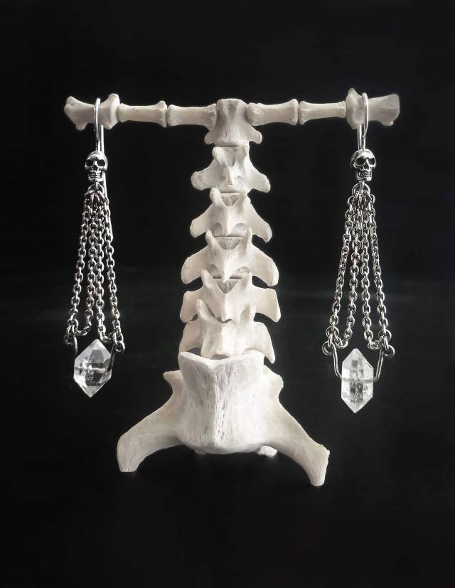 Gothic silver skull earrings with clear crystal gemstone.