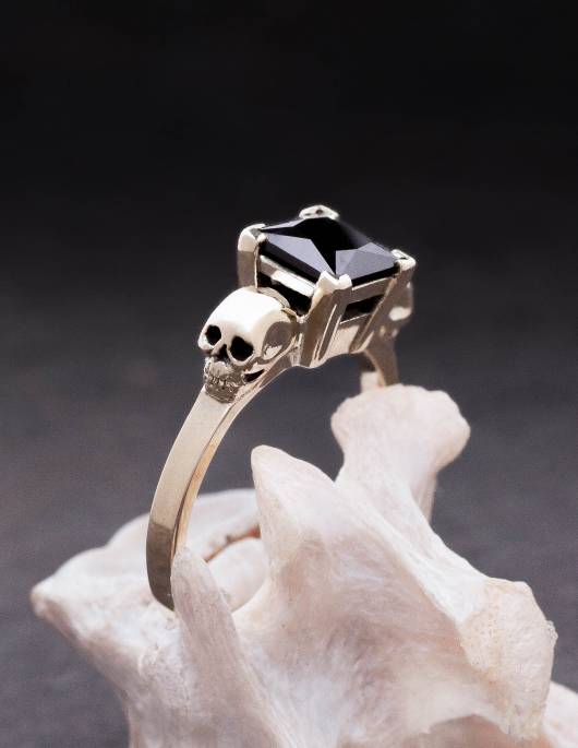 Intricate gold skull ring with princess cut black diamond.